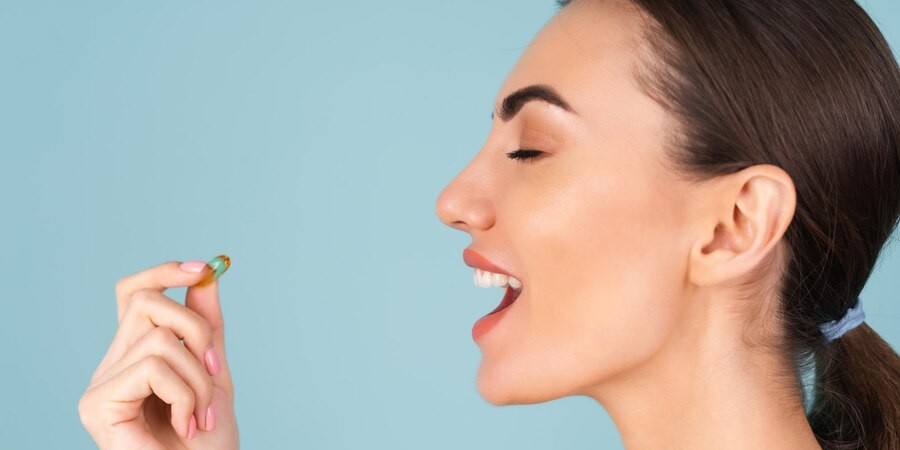 Девушка пьёт витамины