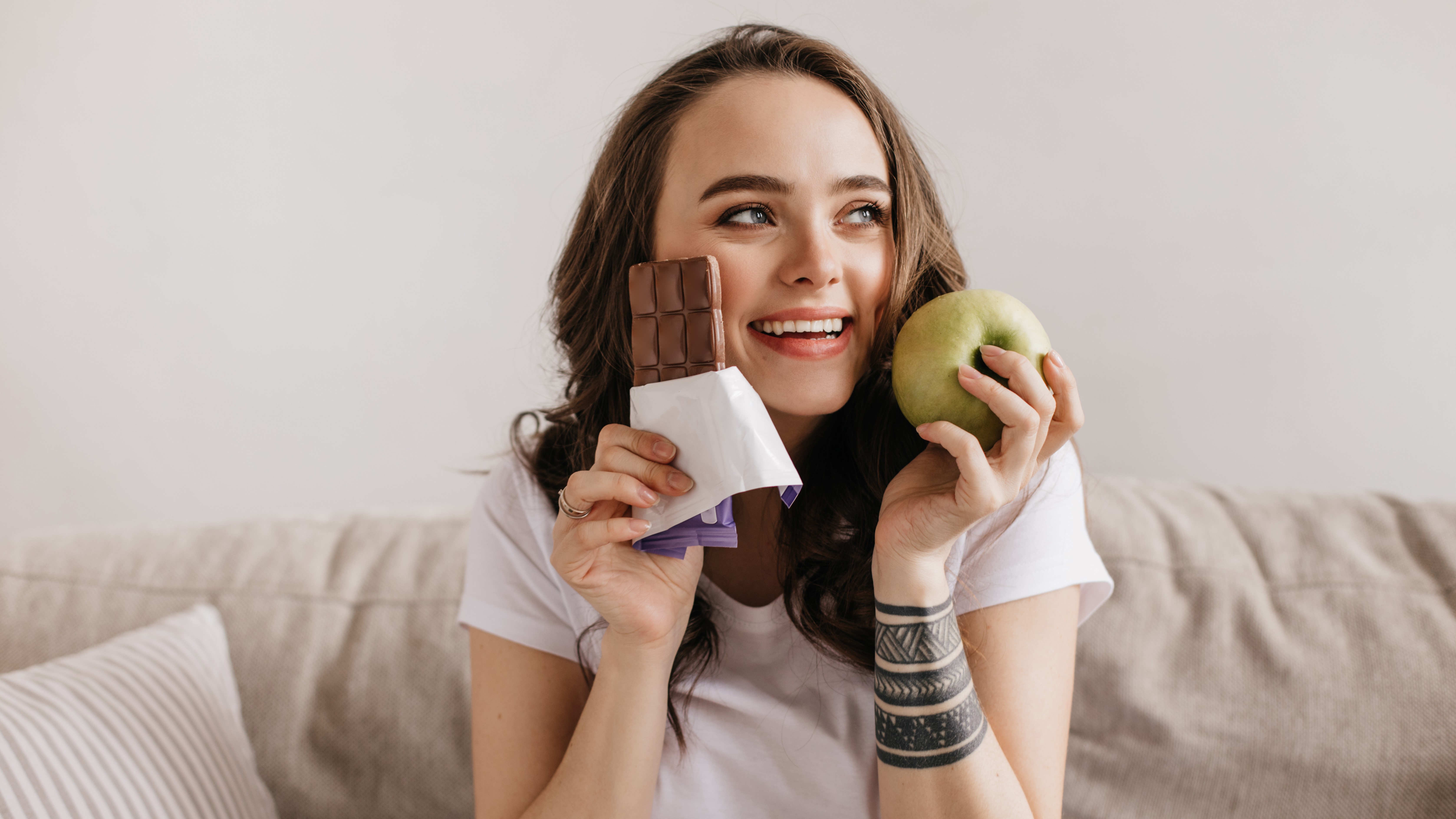 Девушка с шоколадной плиткой и яблоком