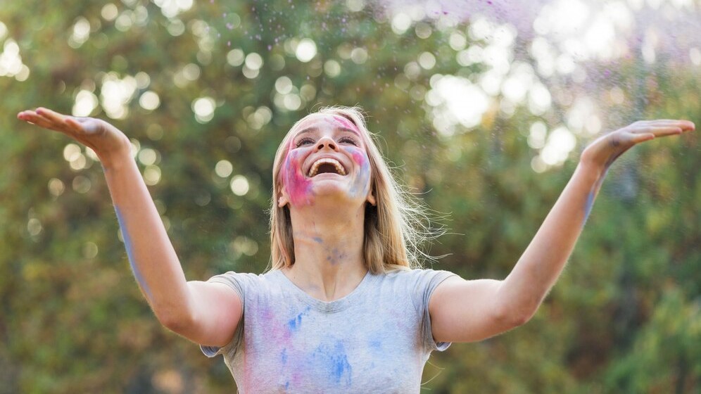 Счастливая женщина бросает цвет в воздухе