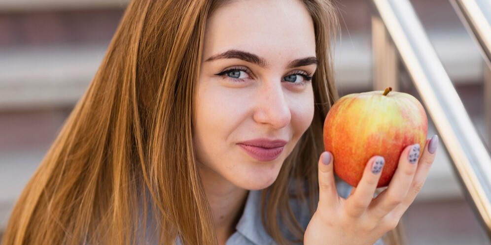 Красивая женщина, держащая яблоко