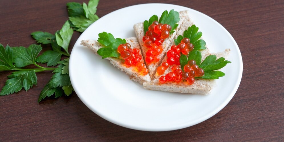 Тарталетки с икрой и петрушкой на тарелке