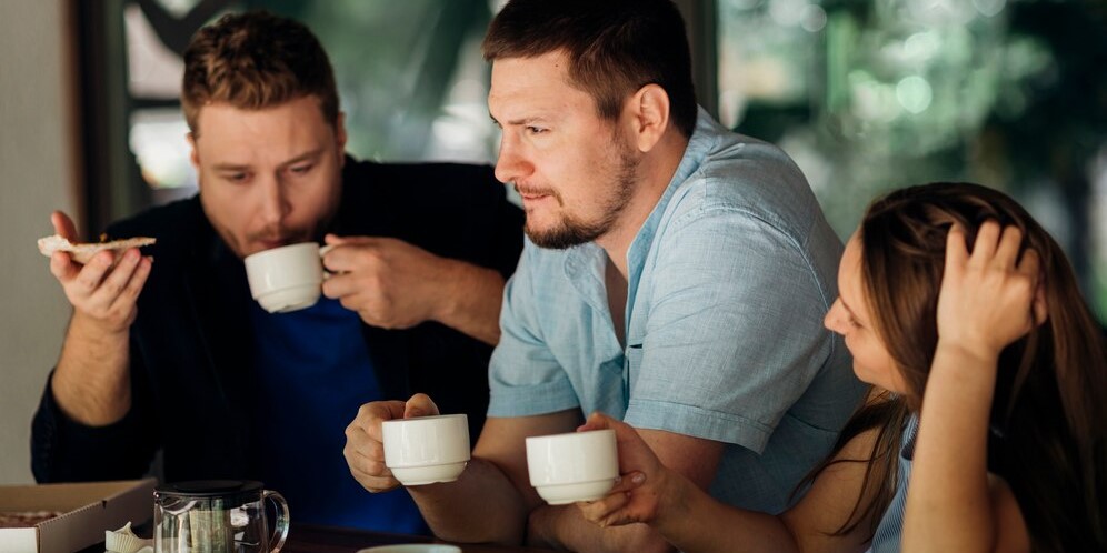 Вдумчивые люди пьют кофе и едят пиццу в кафе