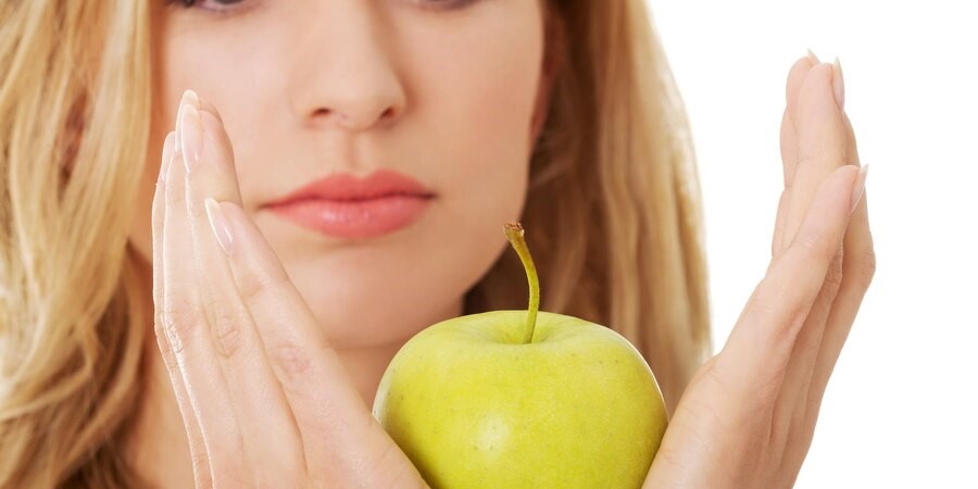 женщина, держащая яблоко 
