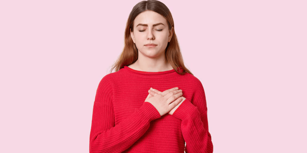 Женщина держит руки на сердце