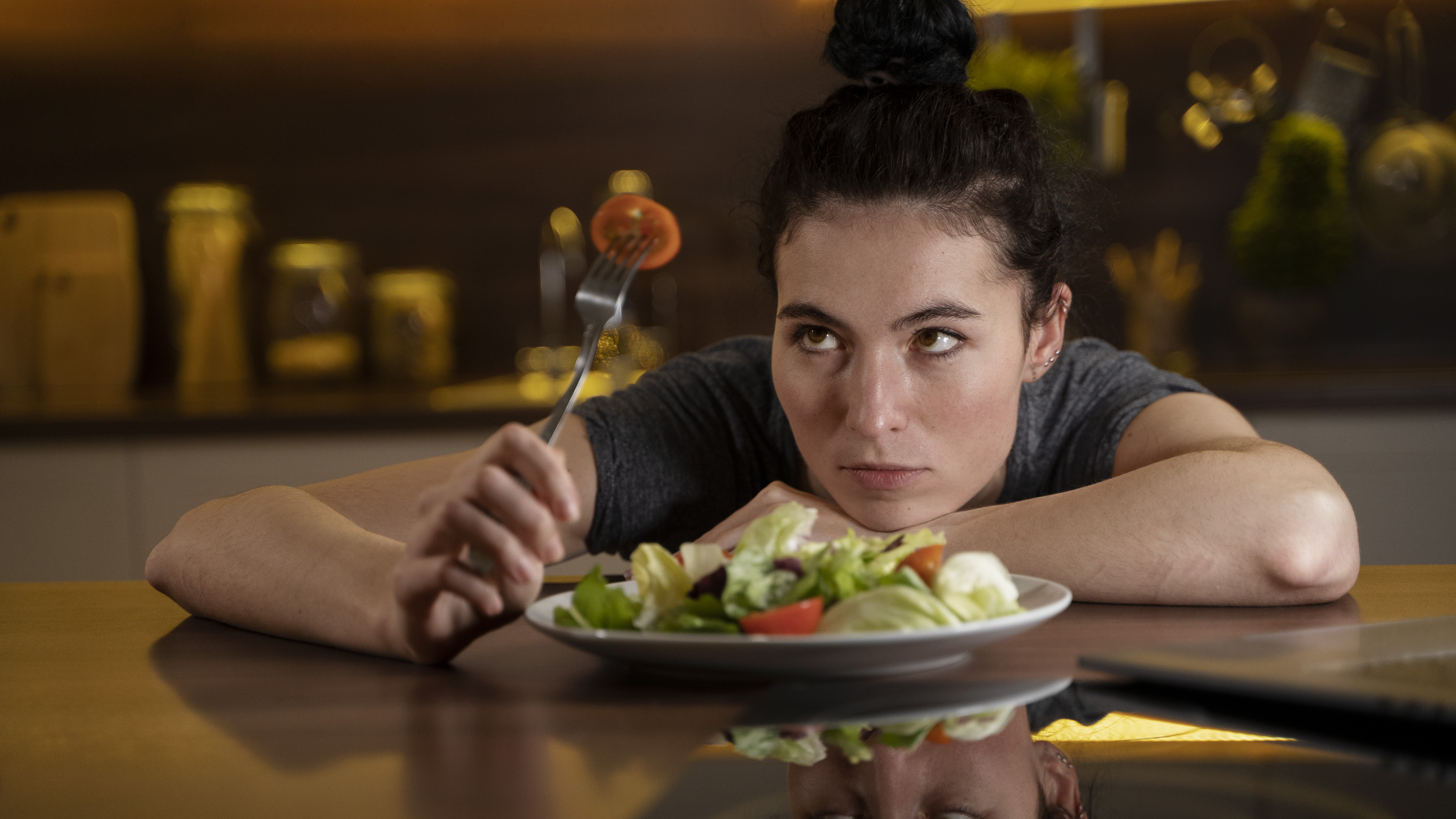 Женщина смотрит на тарелку с полезной едой 