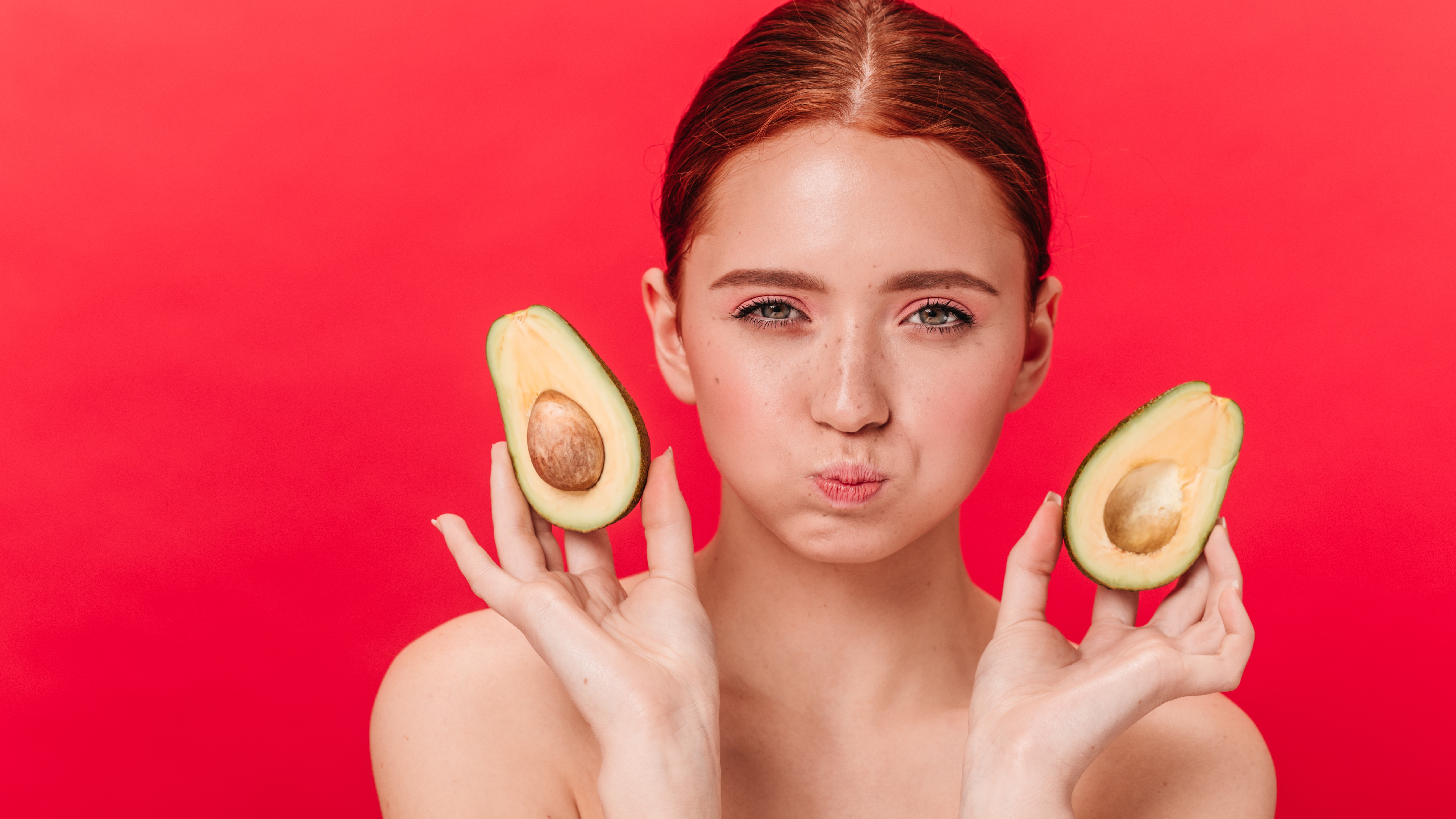 Молодая девушка держит дольки авокадо