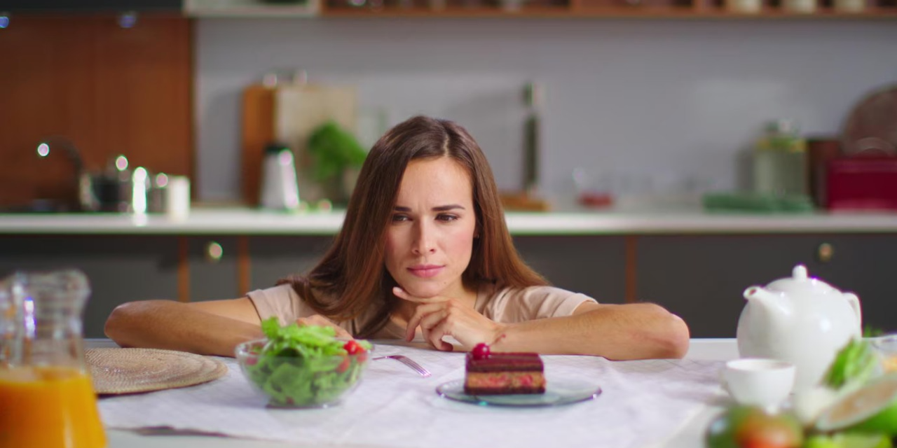 Девушка выбирает между тортом и салатом