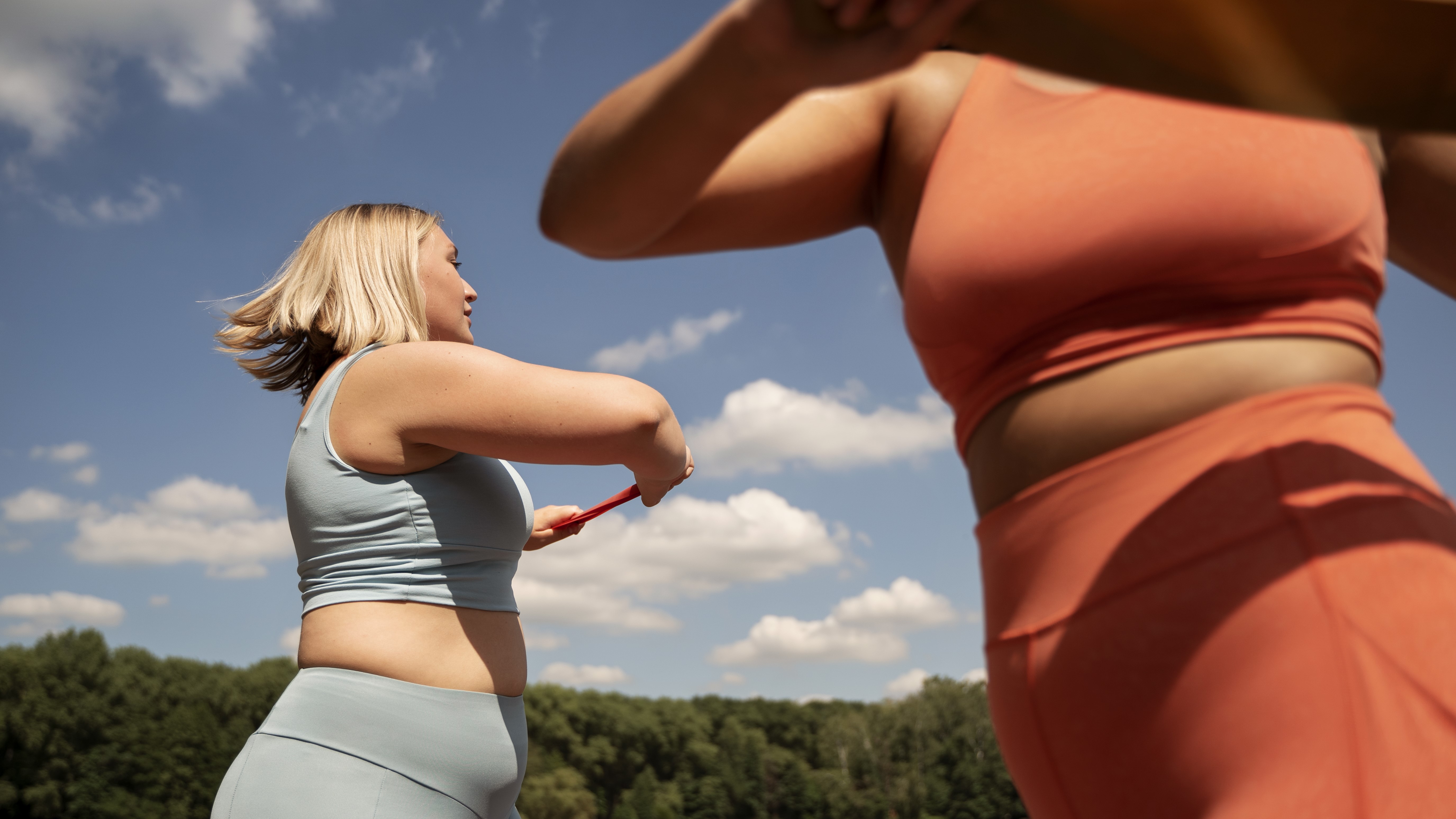 Две женщины средних лет занимаются спортом на улице