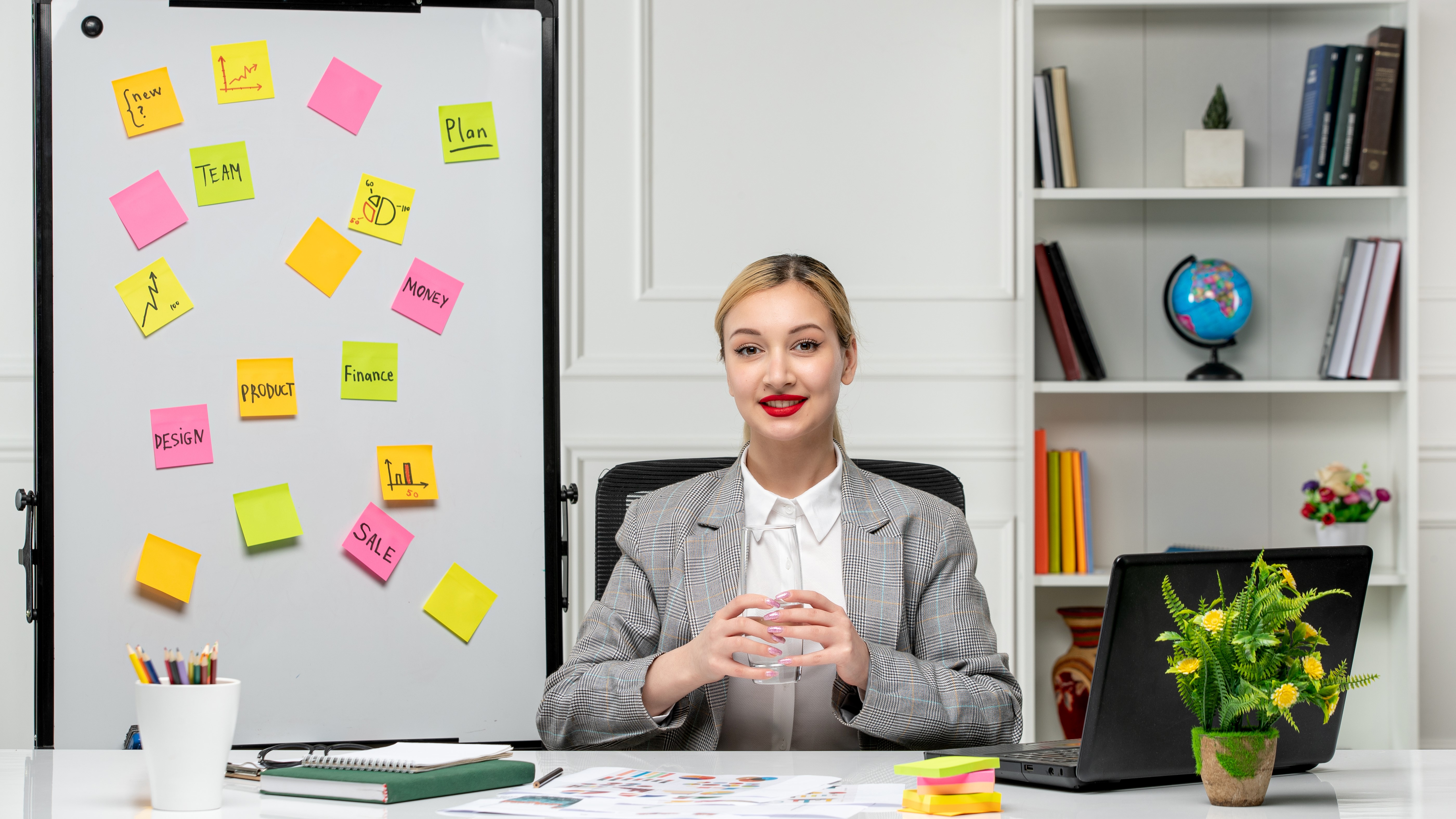 Продающая симпатичная молодая блондинка в сером костюме в офисе