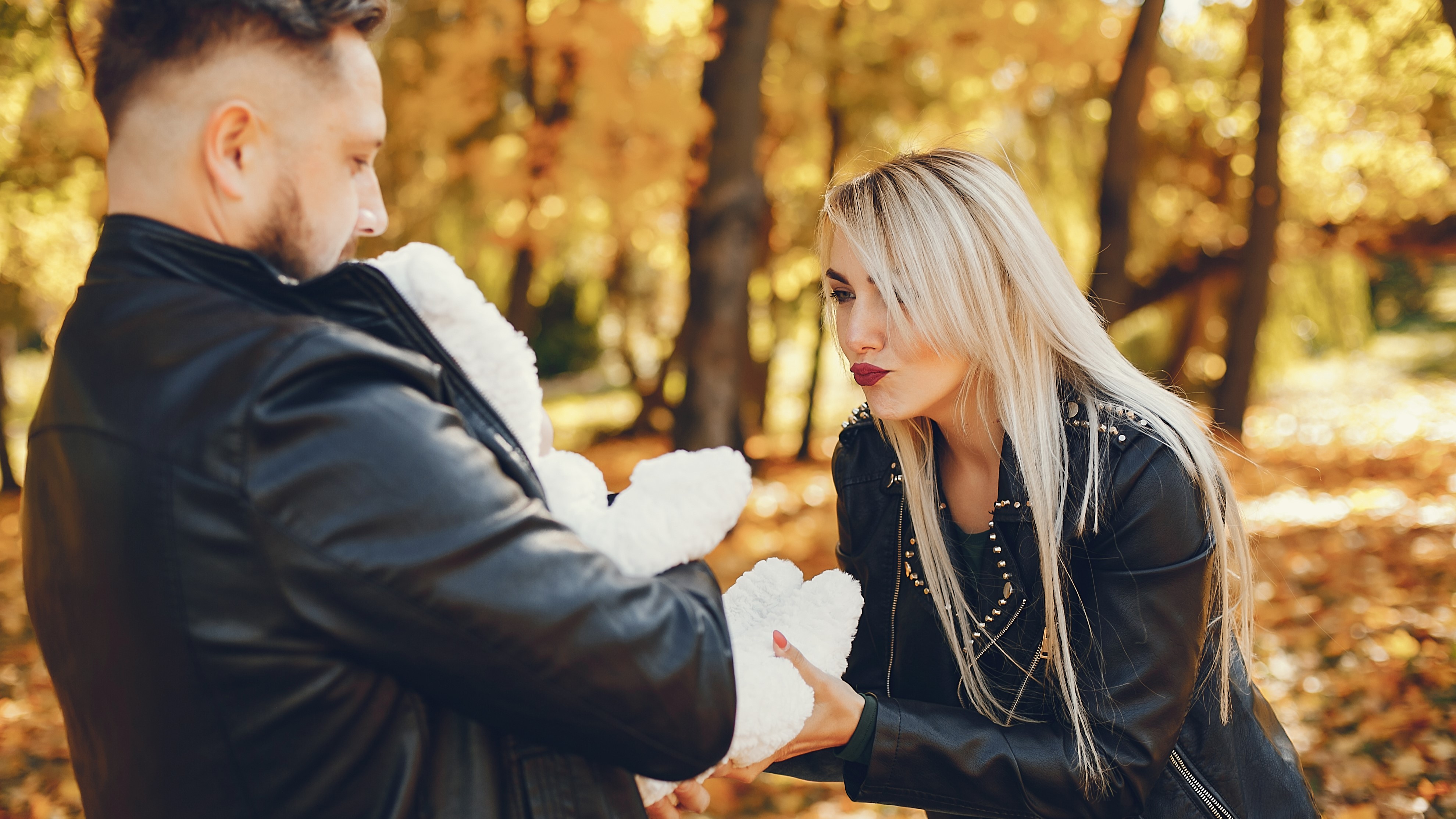 Мужчина дарит своей женщине подарок плющевого мишку